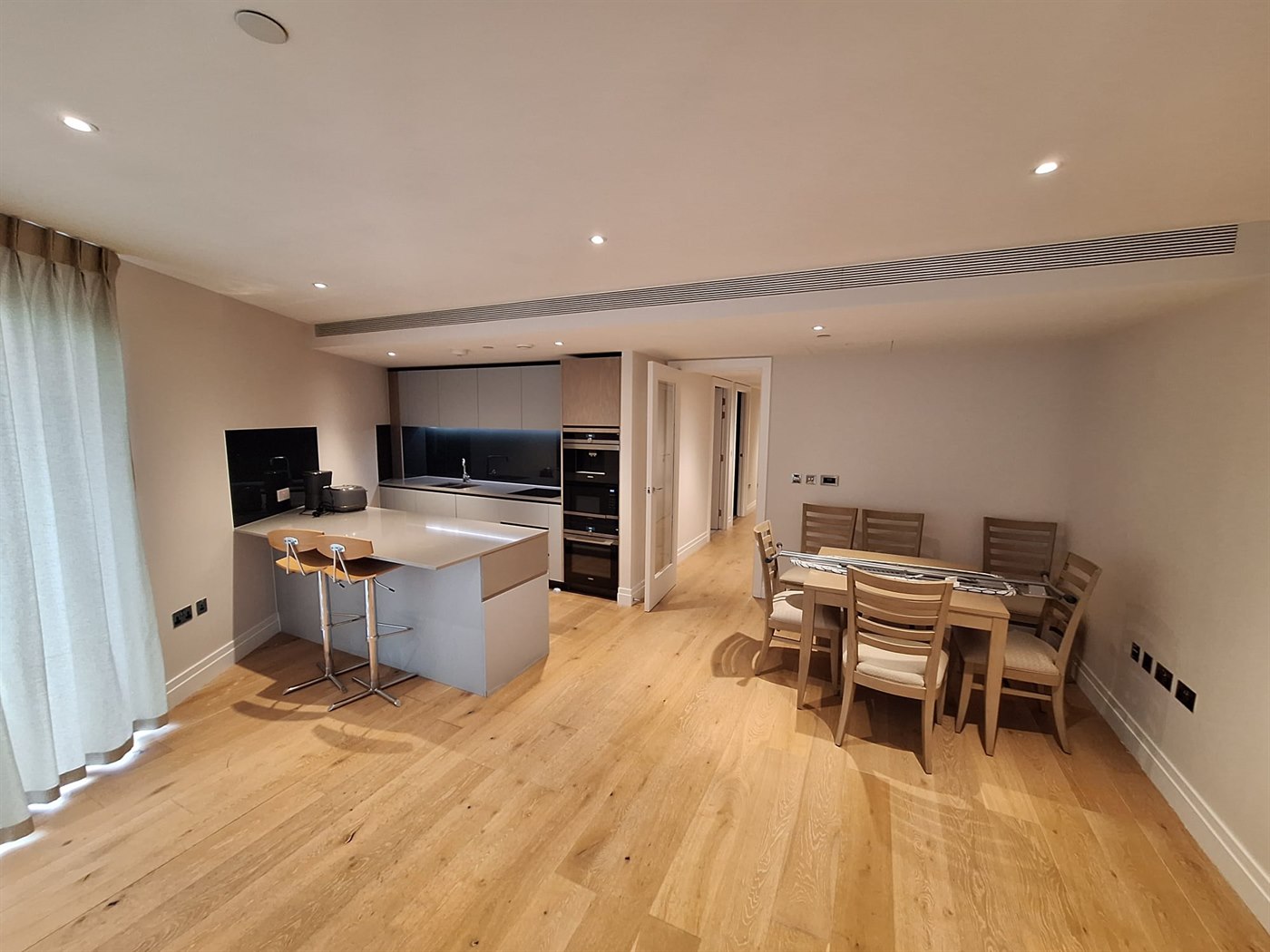 Kitchen-dining area in SW11 apartment with painted walls and ceiling in a soft neutral finish