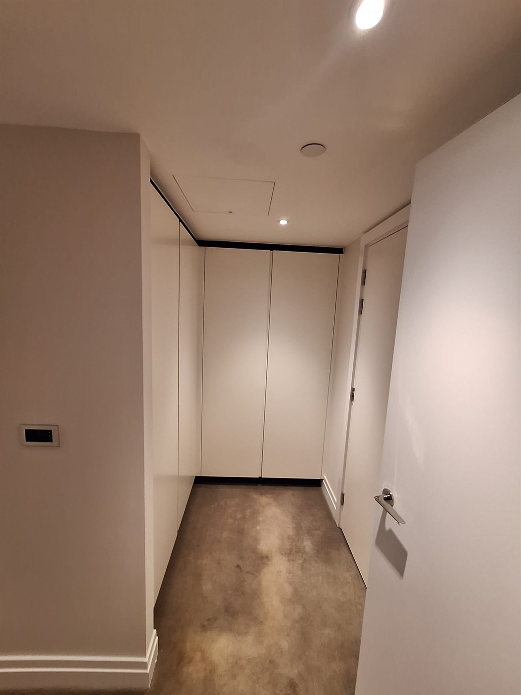 Painted wardrobe hallway area in SW11 apartment with bright ceiling and clean trim